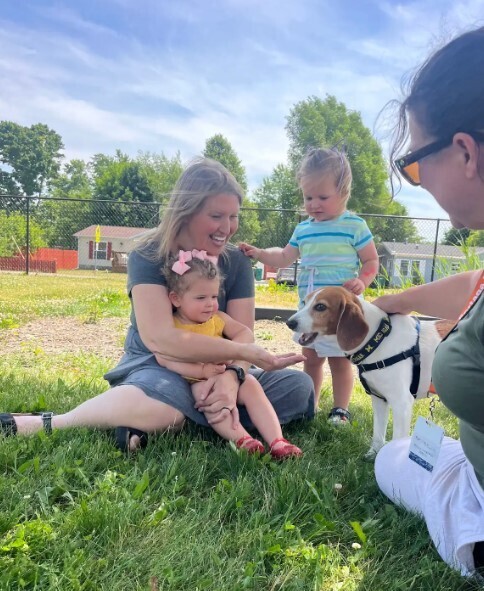 A dog smiling because he got a treat and the lady smiling too.