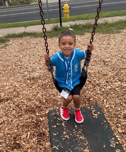 A male student on a swing outside.