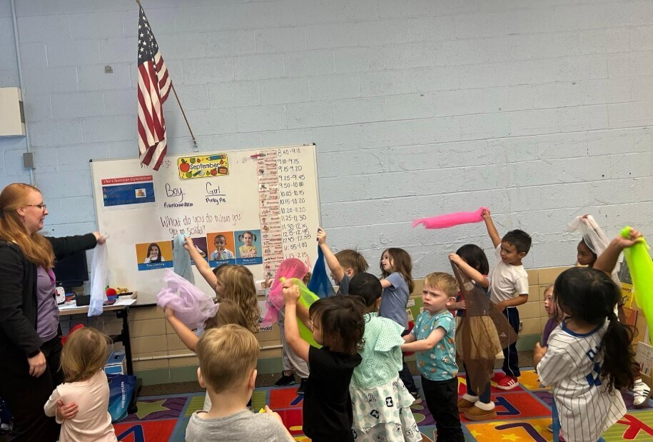 Students dancing with colorful scarves together.