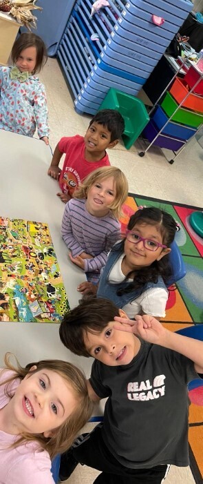 A group of students smiling and showing how they completed their puzzle.