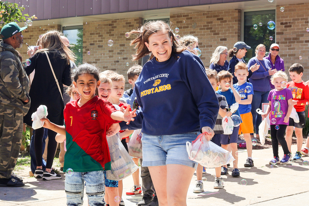 a teacher and student walk out of school smiling