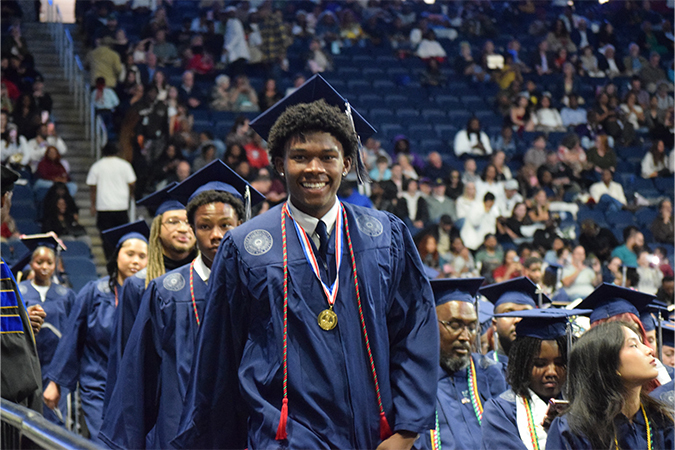 Student leading processional of fellow TCC graduates