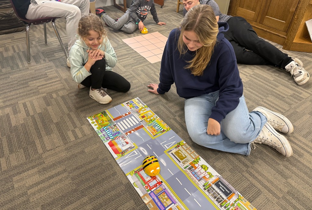 HS students using Beebots with ES students to learn how to code