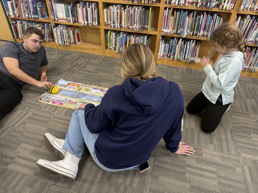 HS students using Beebots with ES students to learn how to code