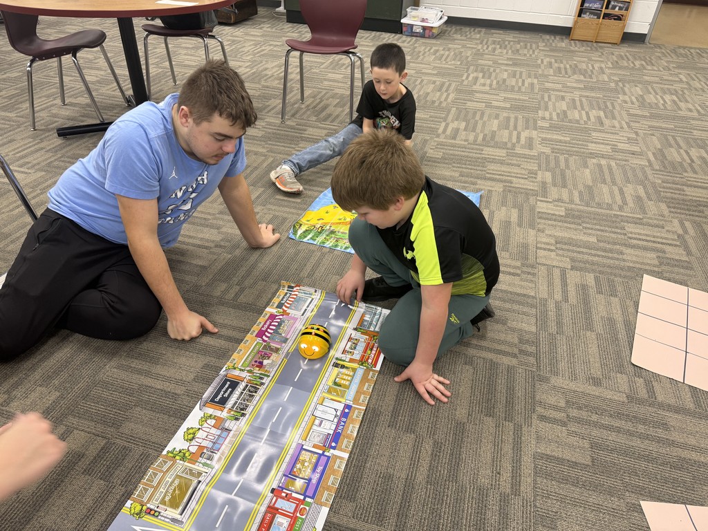 HS students using Beebots with ES students to learn how to code