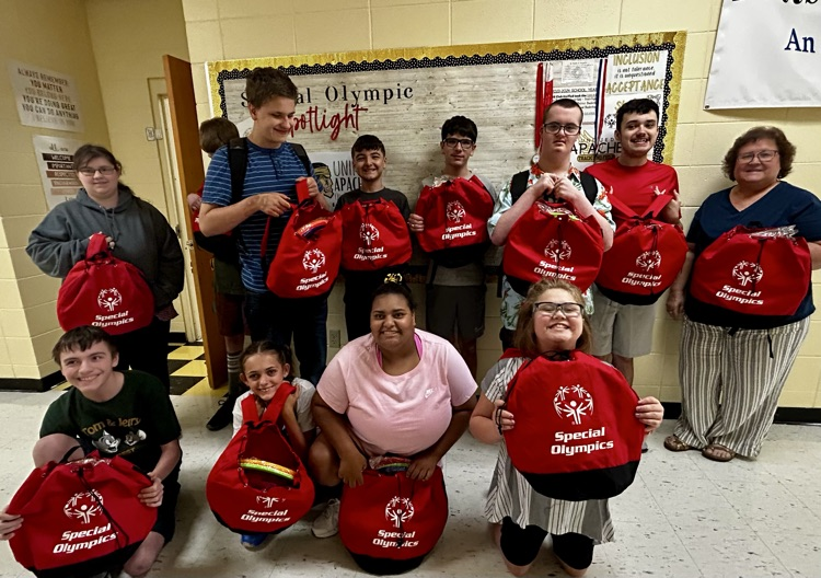 group of students holding red special Olympics bags