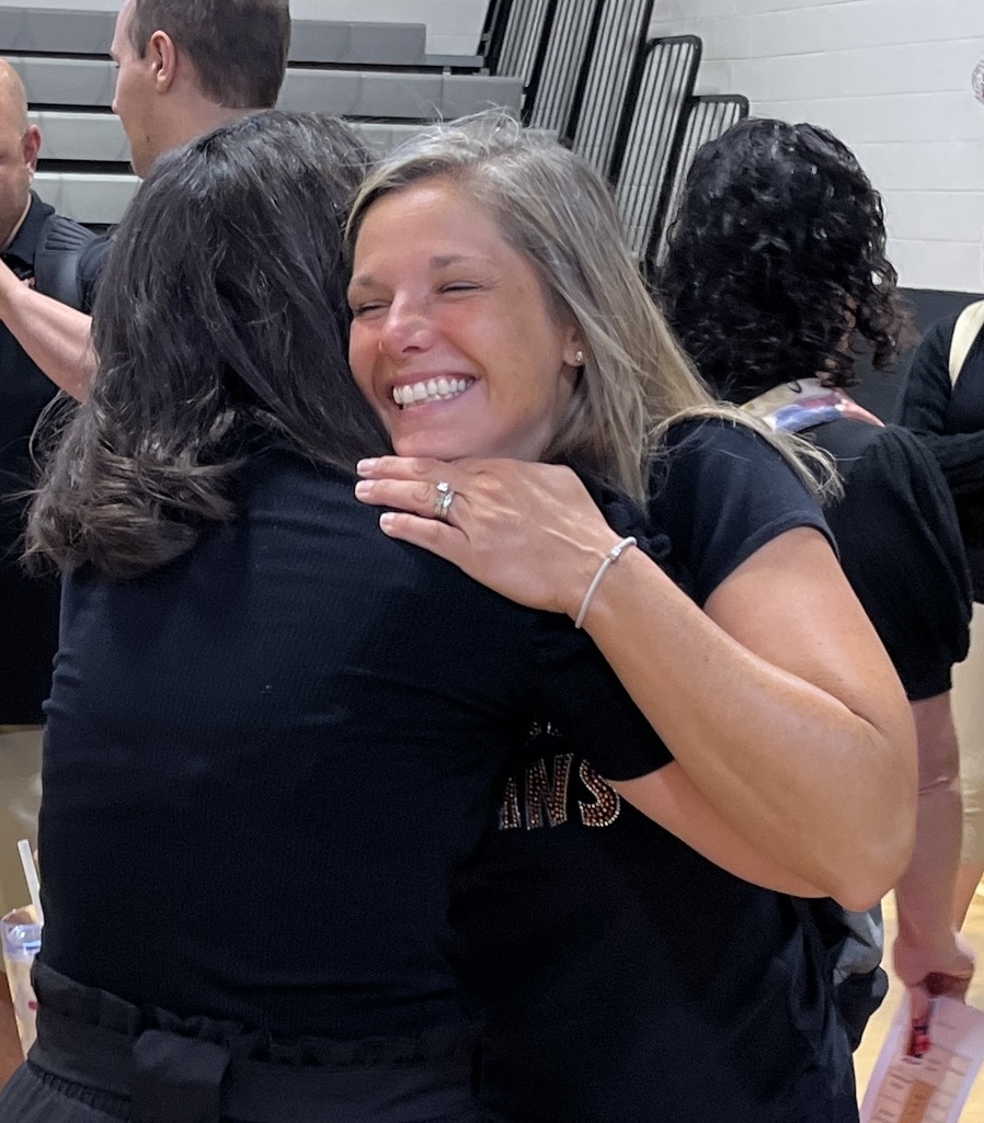Two women hug. 