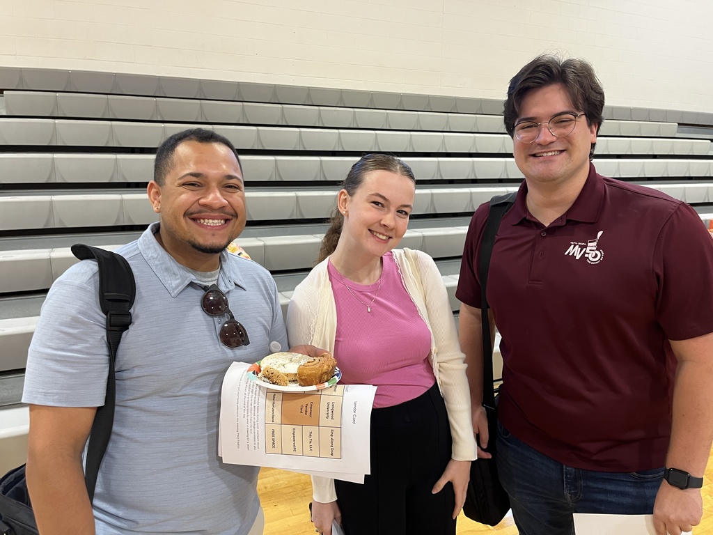 Three people pose for a photo.