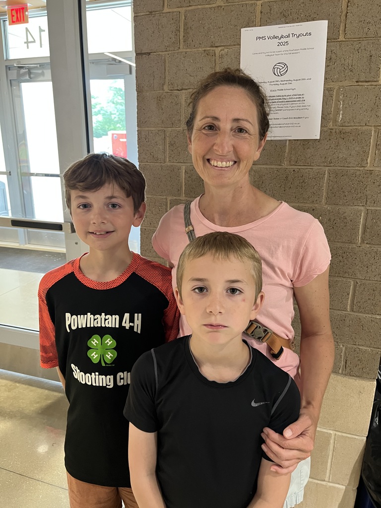 An adult and two children pose for a photo.