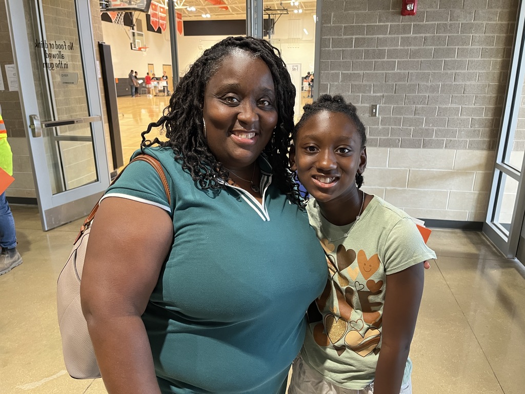 An adult andchild  pose for a photo.