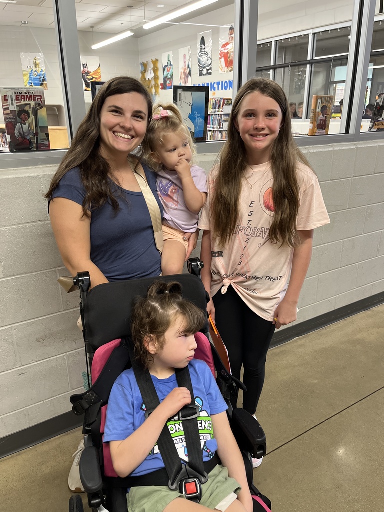 An adult and three children pose for a photo.