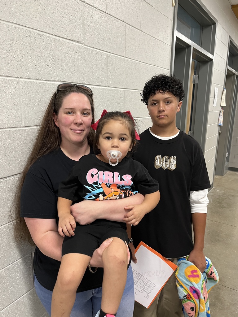 An adult and two children pose for a photo.