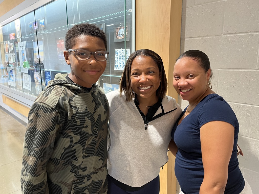 Two adults and a child  pose for a photo.