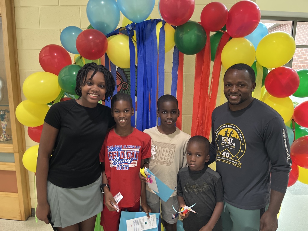 An adult and four children pose for a photo. 