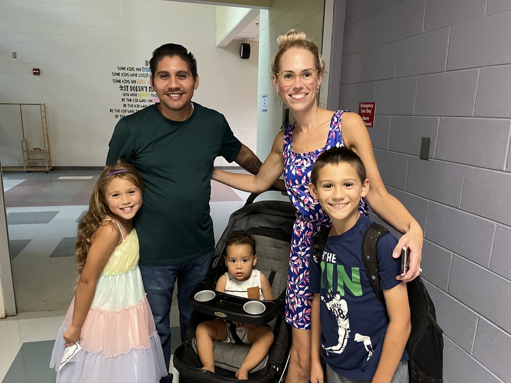 Two adults and three children pose for a photo. 