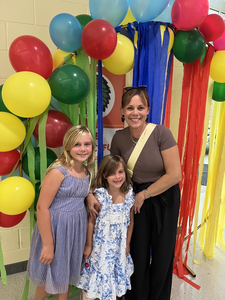 An adult and two children pose for a photo. 