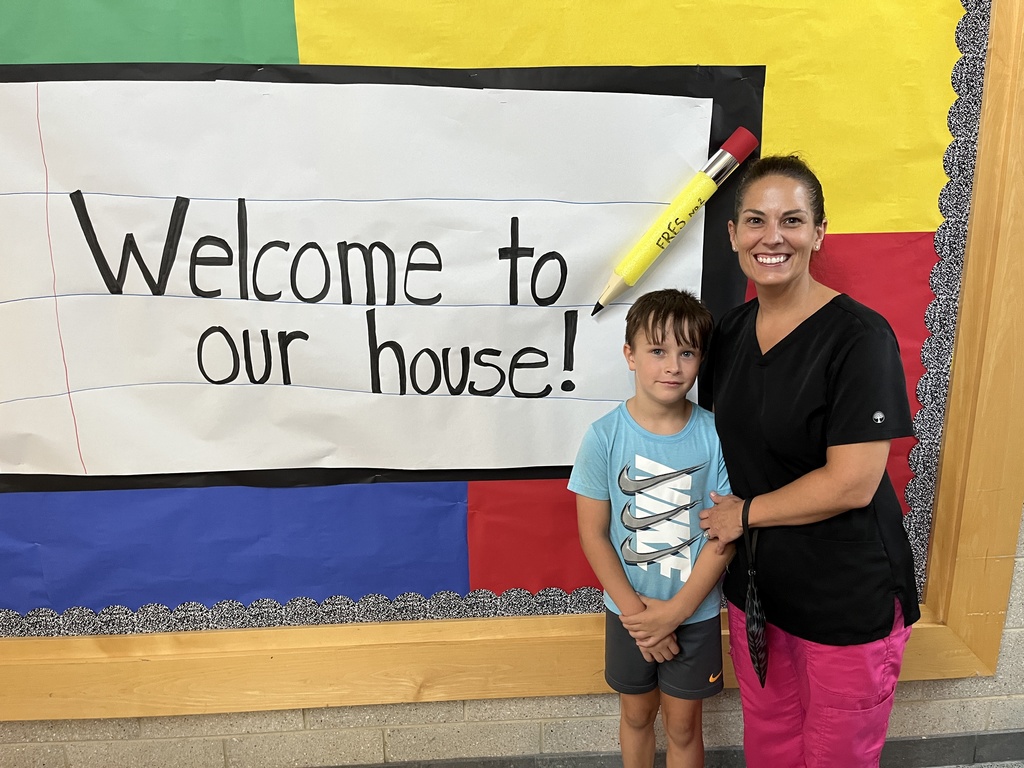 An adult and child pose for a photo. 