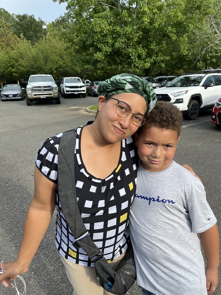 An adult and child pose for a photo. 