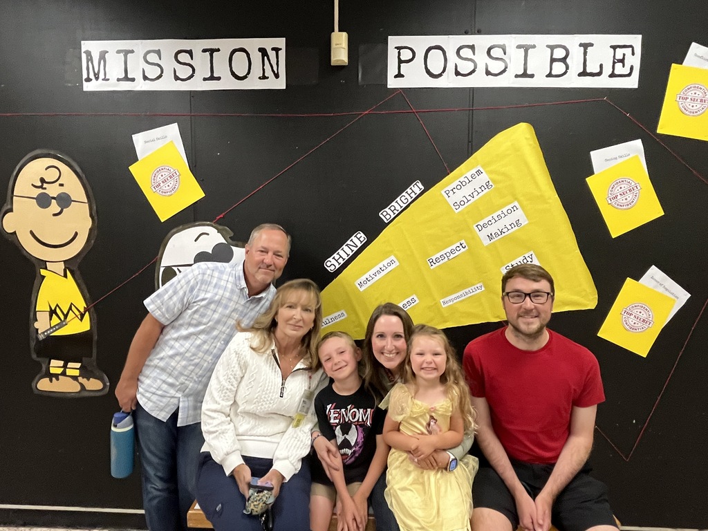Four adults and two children  pose for a photo. 