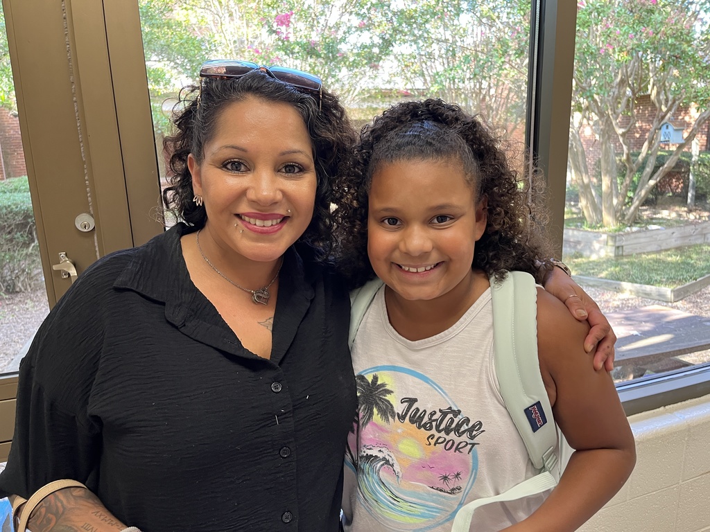 An adult and child pose for a photo. 