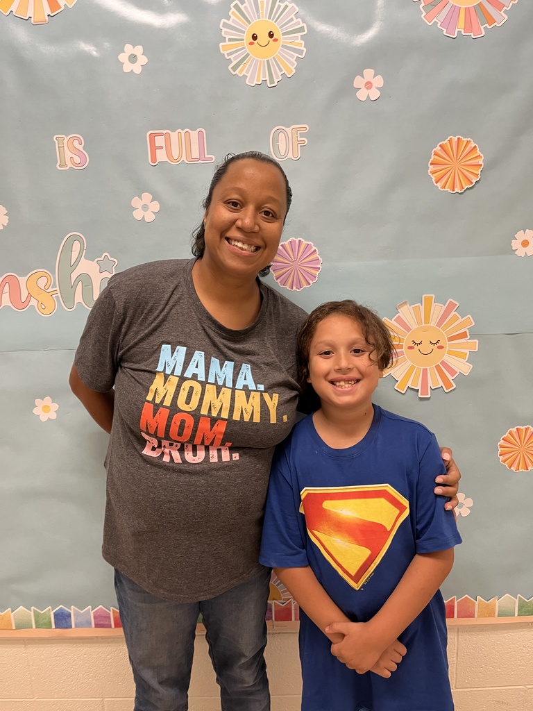 An adult and child pose for a photo. 