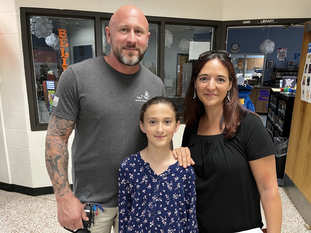Two adults and a child   pose for a photo. 