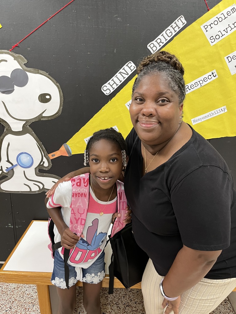 An adult and child pose for a photo. 