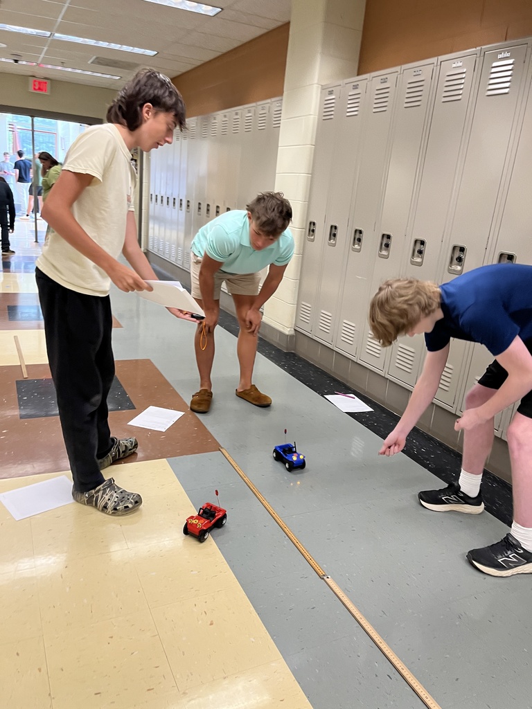 High school physics students conduct an experiment exploring constant velocity using toy cars.