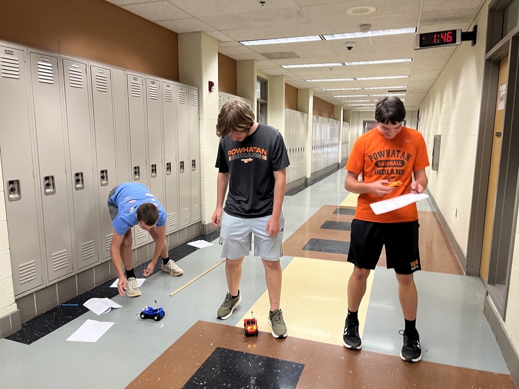 High school physics students conduct an experiment exploring constant velocity using toy cars.