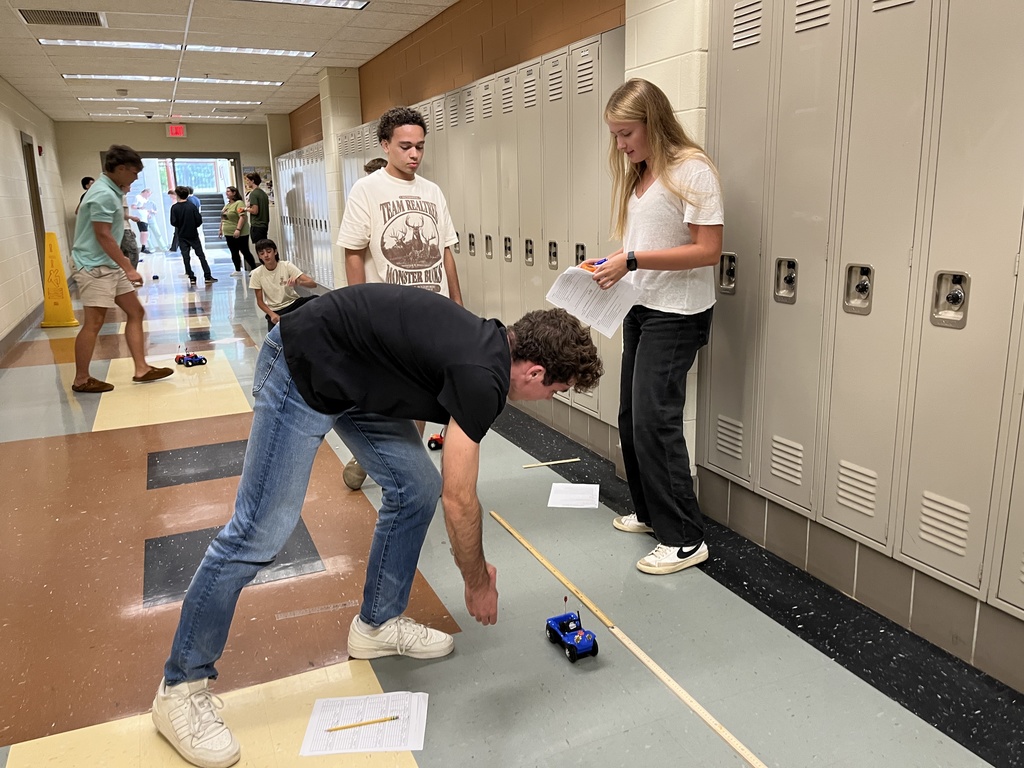 High school physics students conduct an experiment exploring constant velocity using toy cars.