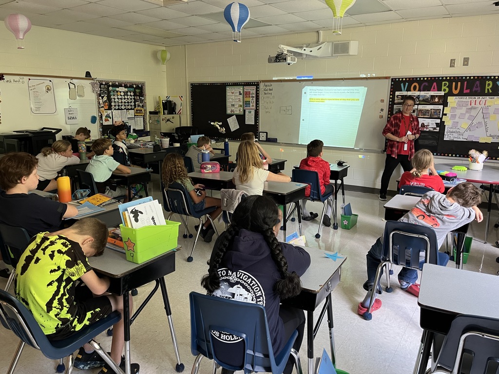 A teacher gives students instructions for their first writing prompt exercise of the school year. 