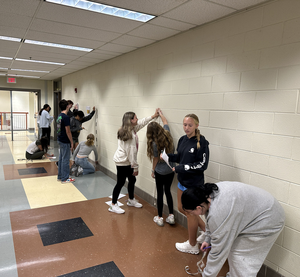 Algebra 1 students complete an activity on measuring height and handspan.