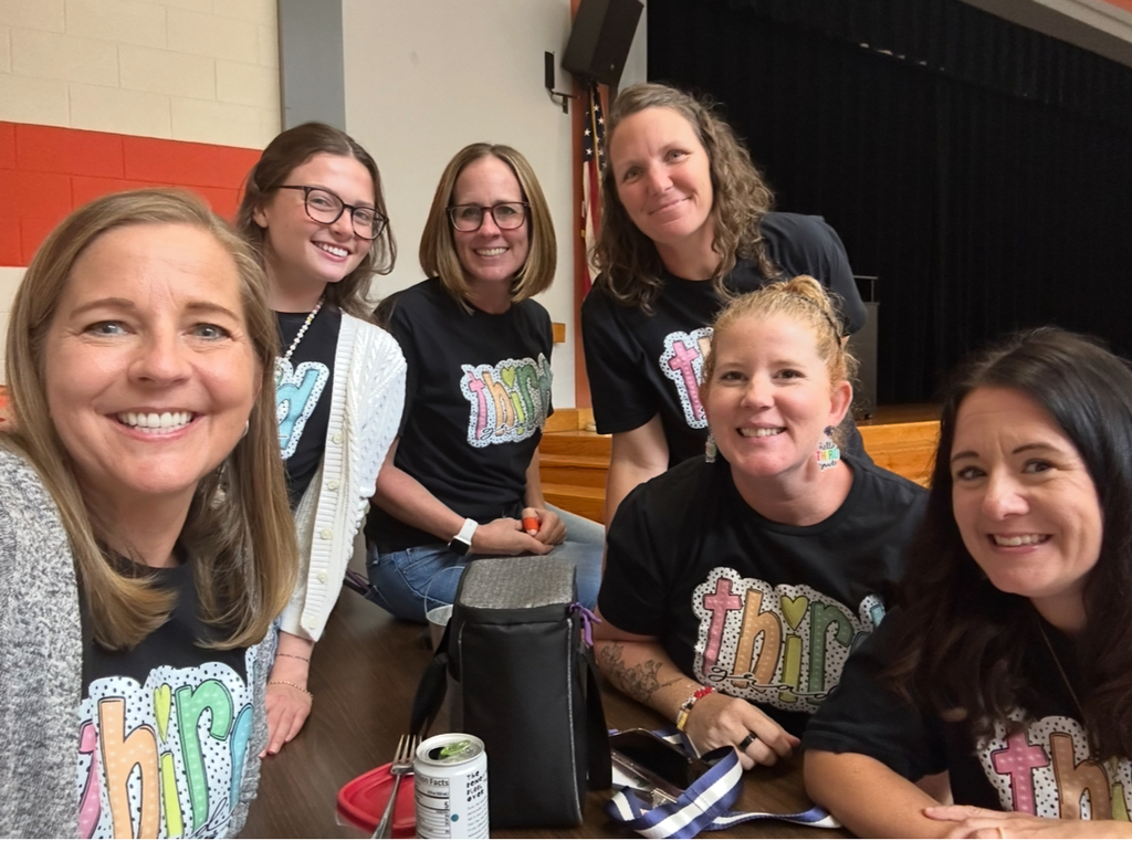 Third grader teachers in matching shirts pose for a photo.
