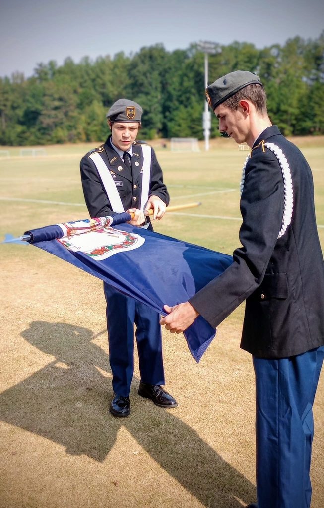 JROTC cadets put away a flag after presenting  the Colors.