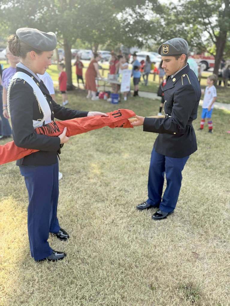 JROTC cadets put away a flag after presenting  the Colors.