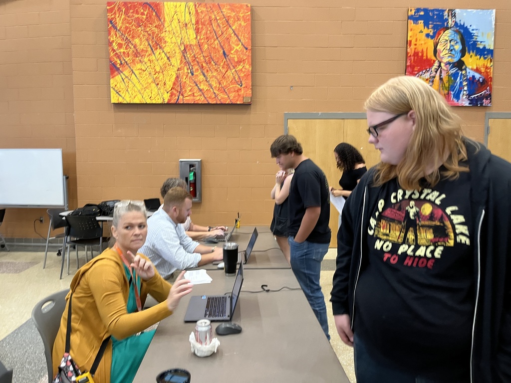 Students check in with staff members to receive their Chromebooks. 