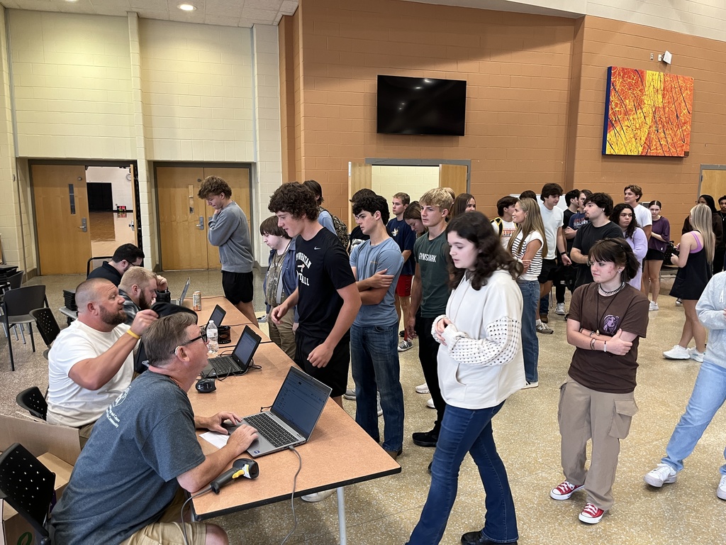 Students check in with staff members to receive their Chromebooks. 