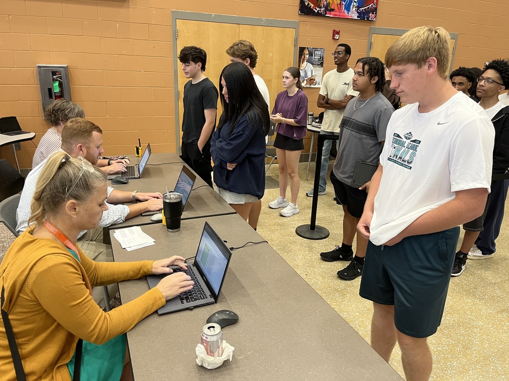 Students check in with staff members to receive their Chromebooks. 