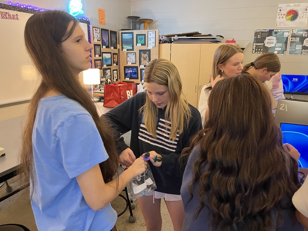 Students take bracelets out of a bag. 