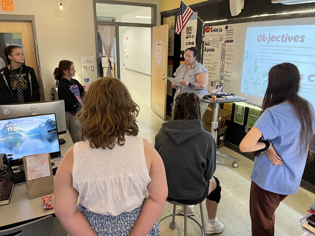 A yearbook teacher leads her students in a yearbook commitment ceremony. 