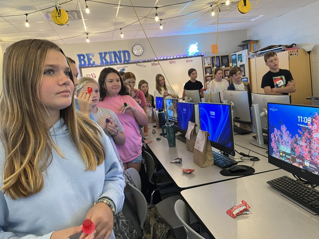 A yearbook teacher leads her students in a yearbook commitment ceremony. 