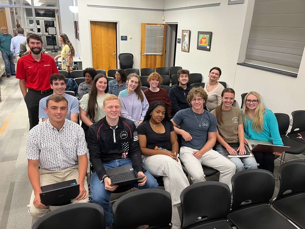 A group of students and their teacher pose for a photo. 