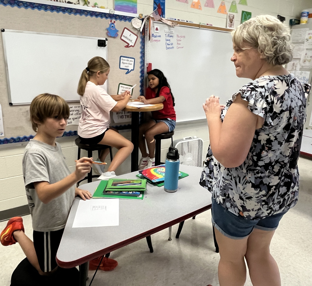 Students use data from a survey about favorite ice cream flavors  to create a bar graph. A teacher answers a question.