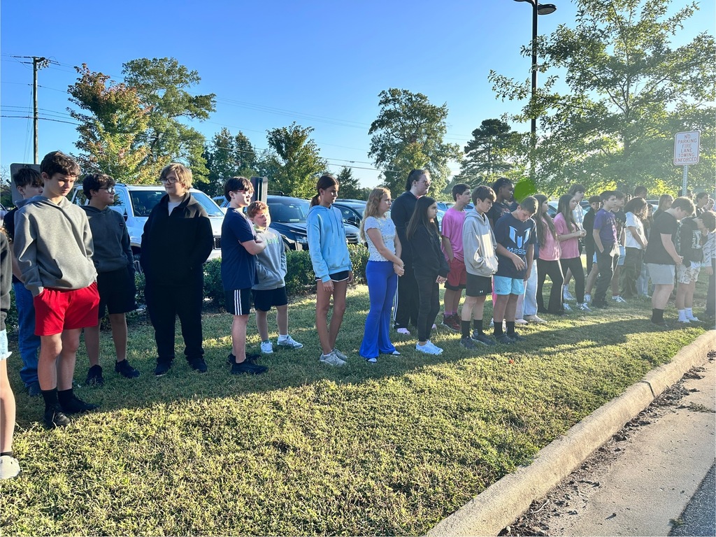 Middle school students observe  a 9/11 ceremony in front of their school.