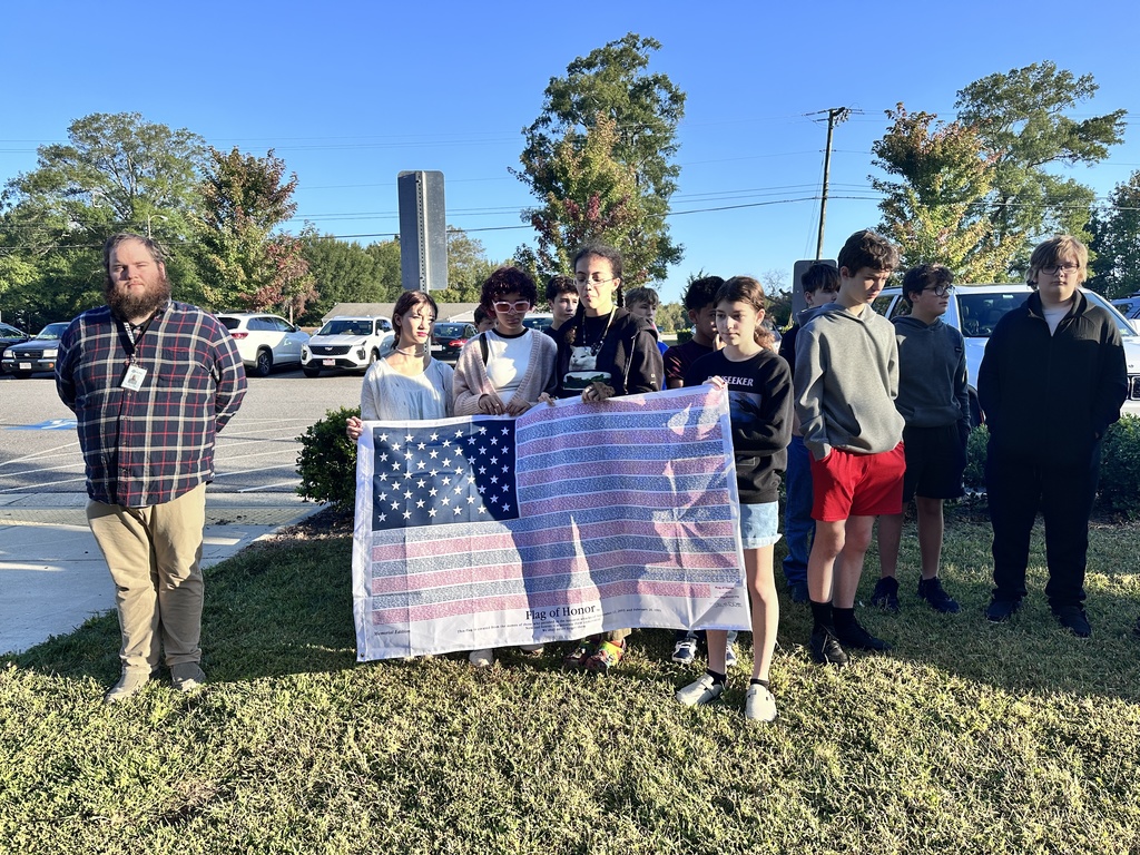 Middle school students observe  a 9/11 ceremony in front of their school.