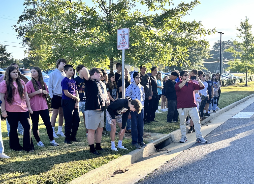 Middle school students observe  a 9/11 ceremony in front of their school.