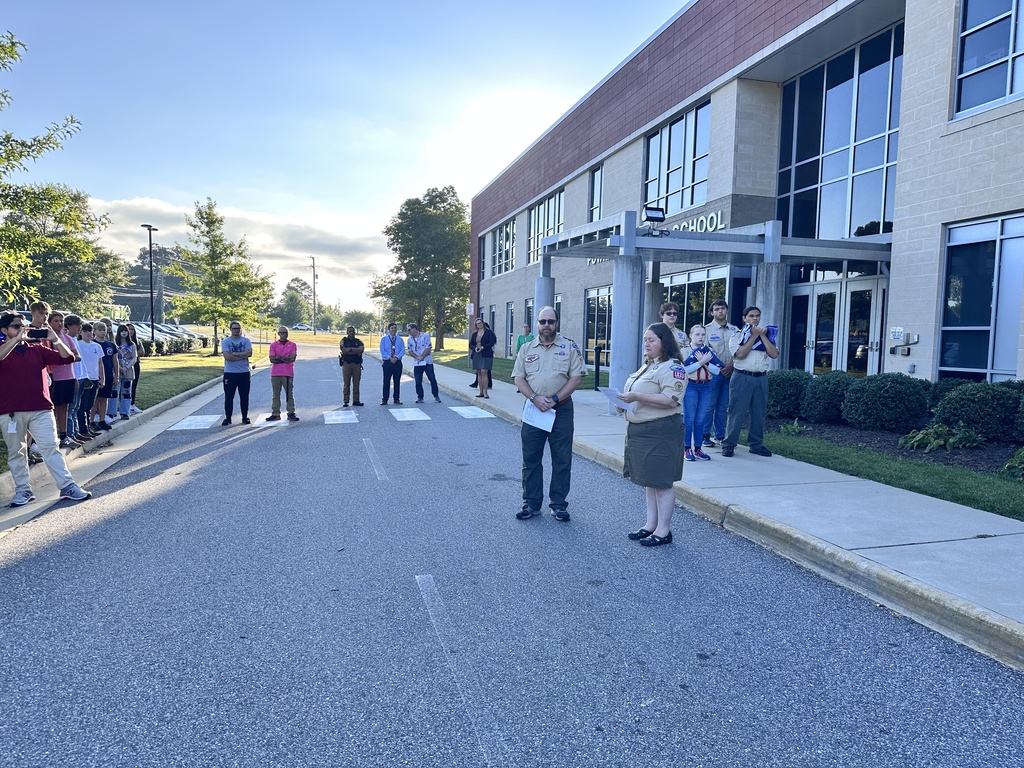 A 9/11 ceremony is held in front of a middle shcoo.