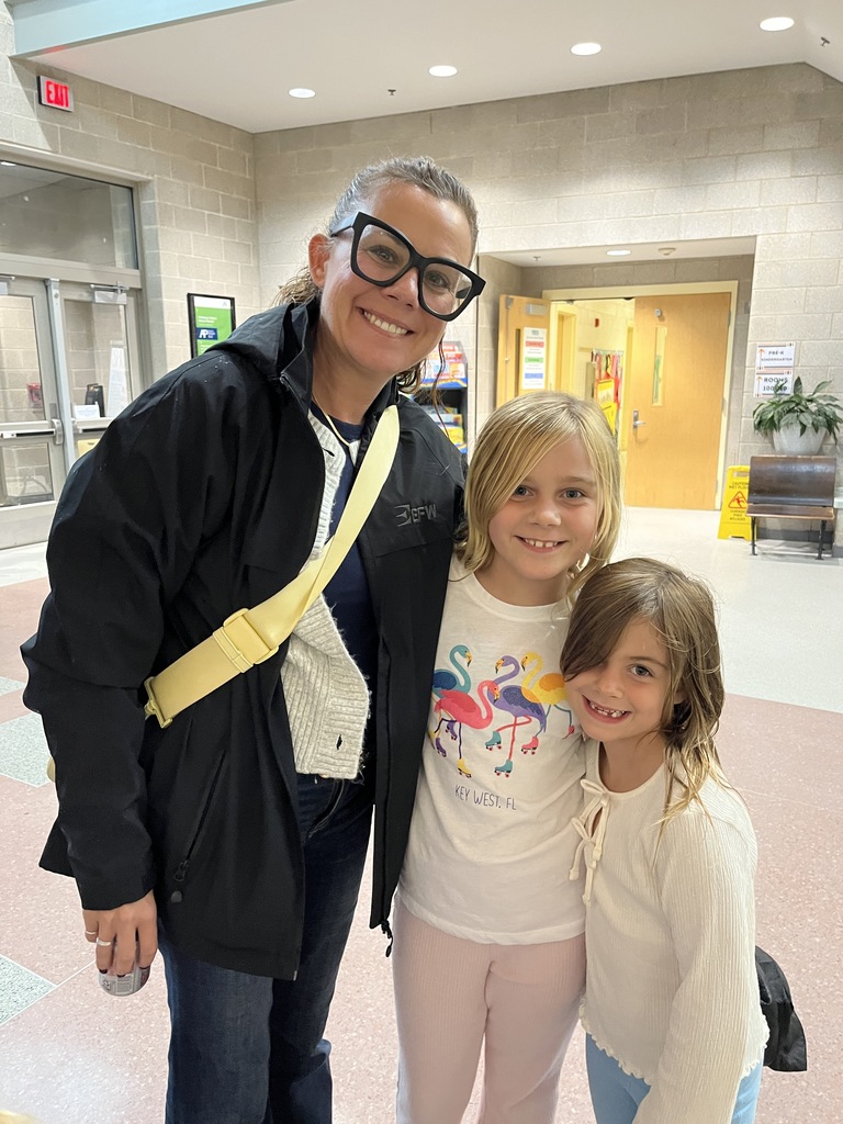 An adult and two children pose for a photo.