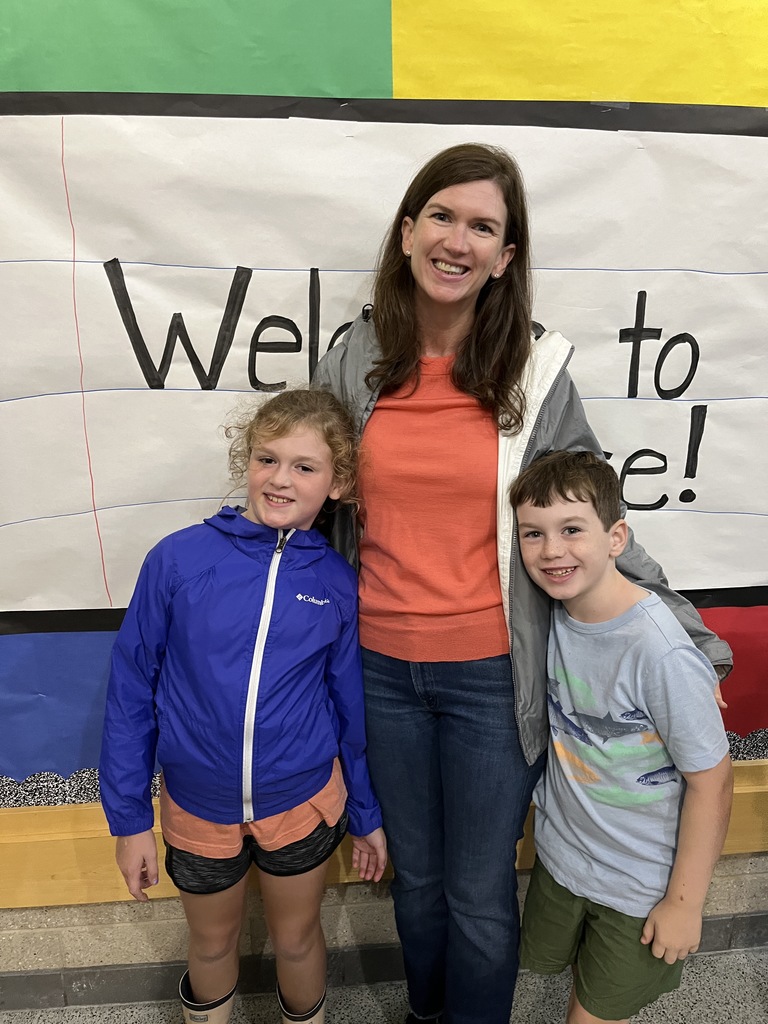 An adult and two children pose for a photo.