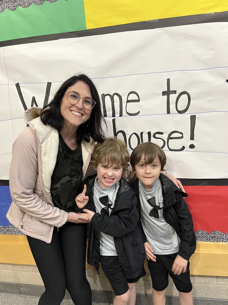 An adult and two children pose for a photo.